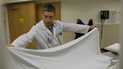 卫生保健工作者把白布在医院的床上