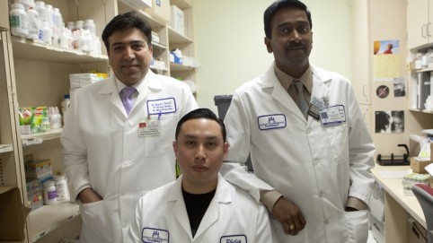 三个男制药工人在他们的白色实验服