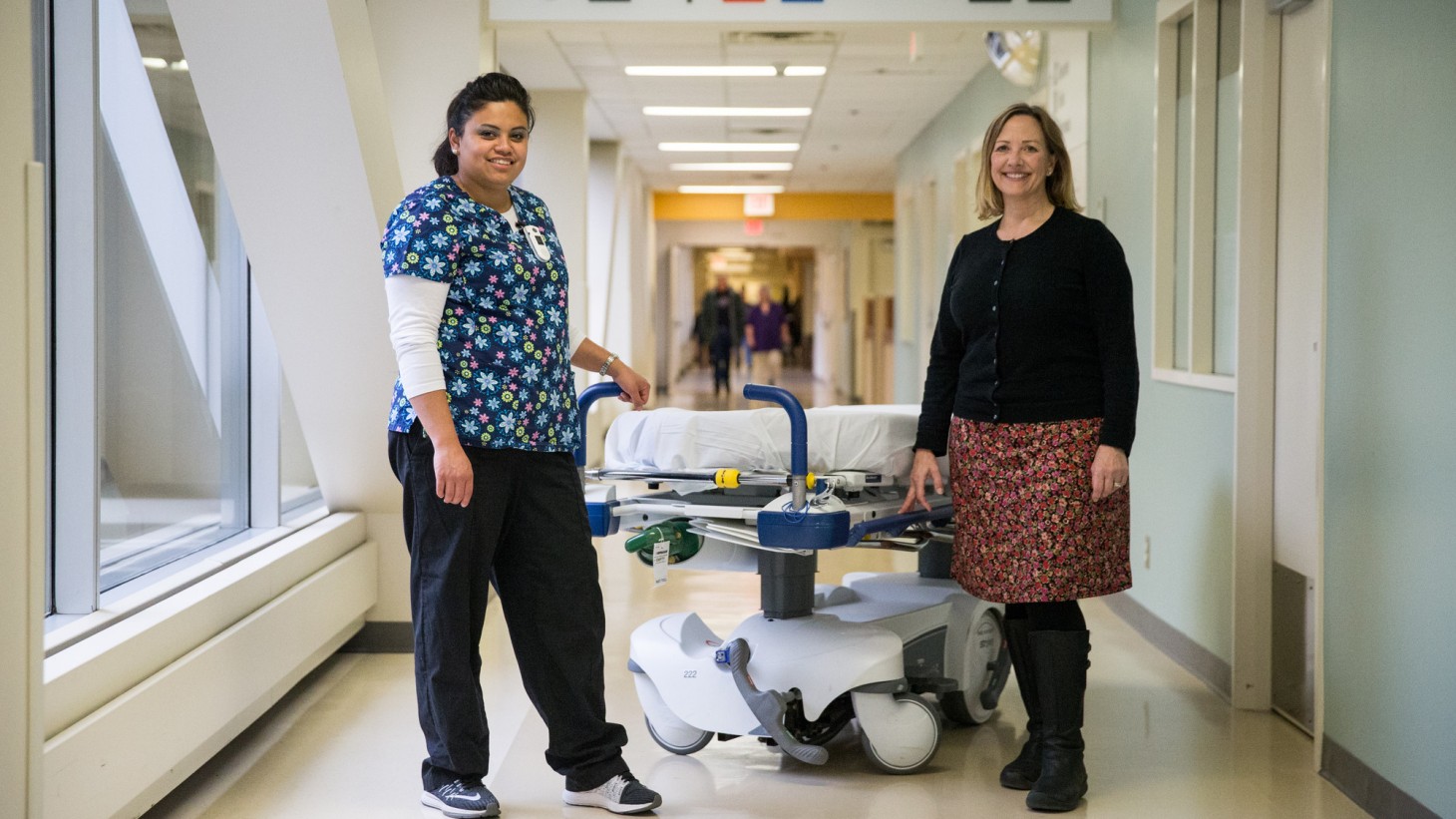埃斯特·洛根和玛莎·威特站在医院走廊的轮床旁。