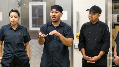 3厨房员工穿着黑色讨论一个严肃的问题