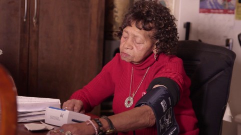 老年妇女检查她的血压在她自己的家里