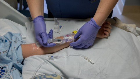 一双手正在给病人的手臂上进行静脉注射